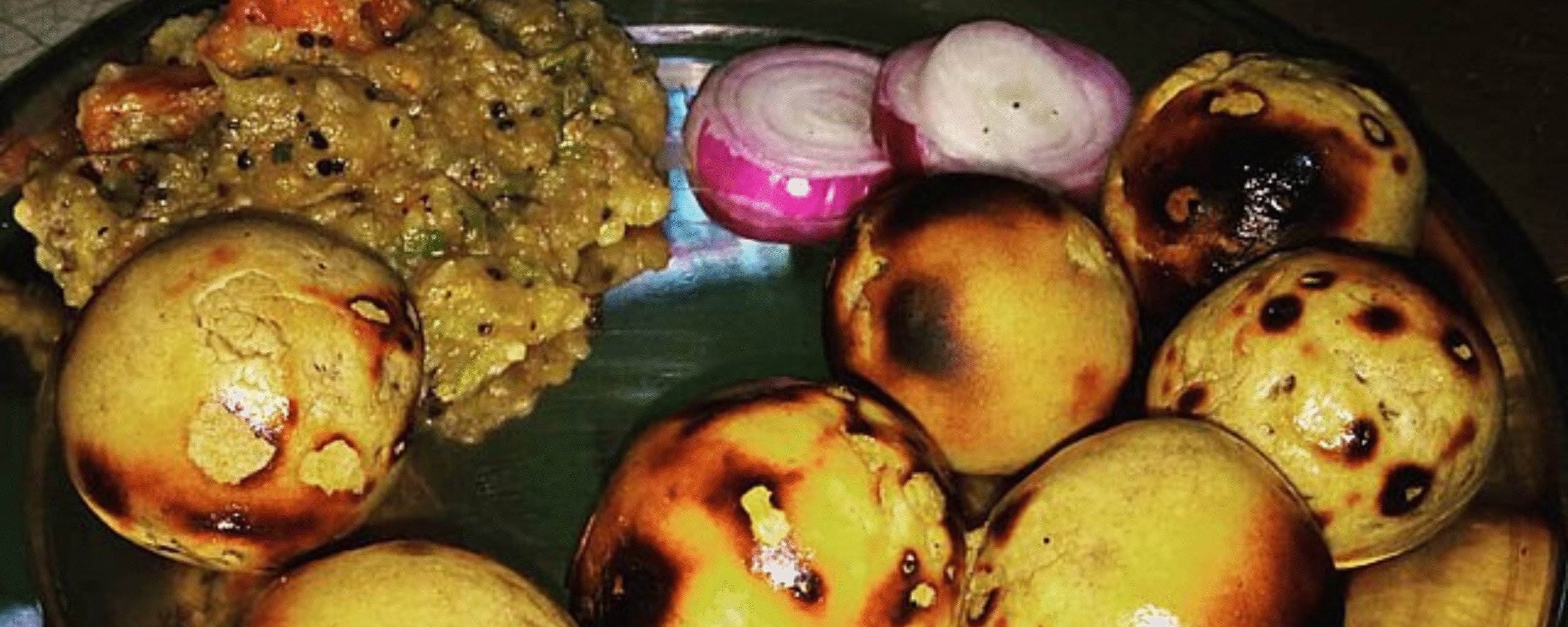 Authentic Litti Chokha with roasted wheat balls, chokha, and onions on plate