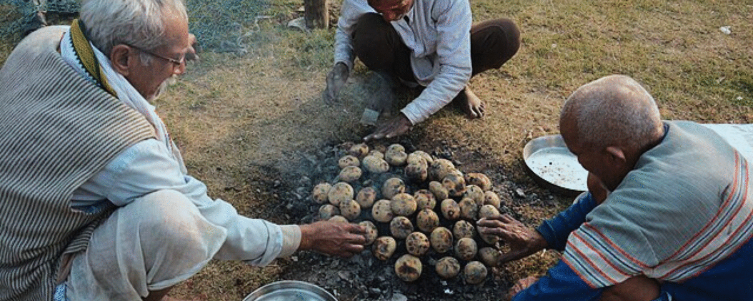 Traditional Litti Chokha being prepared on open fire in Indian village.